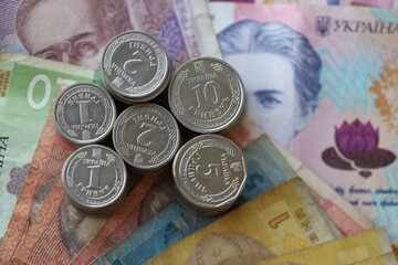 Few stacks of ukrainian money coins lies on old hryvnia banknotes