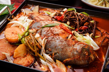 Spicy fish stew with potatoes, onions and vegetables