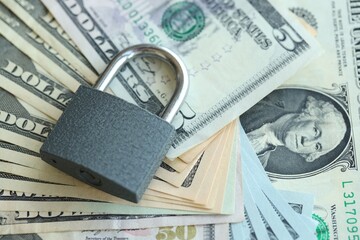 USD Dollar bills and a closed lock as a concept for imposing economic sanctions.