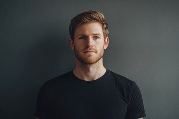 Fototapeta premium Man in Black Shirt Standing Against Gray Wall