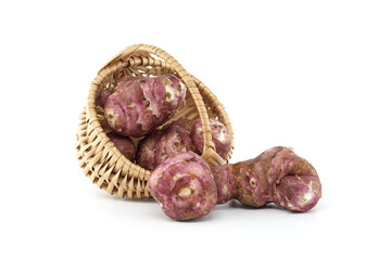 Fresh Jerusalem Artichokes Spilling from Woven Basket on White