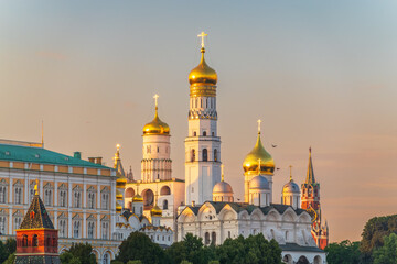 Ivan the Great Bell Tower, with Assumption Belfry on the right in Moscow Kremlin. Blue sky background with sunbeams