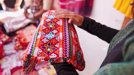 Close up shot of woman buying handicraft clothes from Rann Utsav market in Kutch, Gujarat, India. Beautiful Kutchi Handicraft arctician designer cloth in local street market. Shopping concept. 