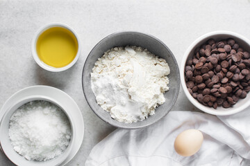 overhead view of mise en place for homemade chocolate chip cookies, ingredients for making chocolate chip cookies on a marble countertop