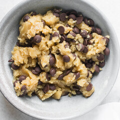 Overhead view of chocolate chip cookie dough, top view of homemade chocolate chip cookie dough in a bowl on a white background, process of making chocolate chip cookies