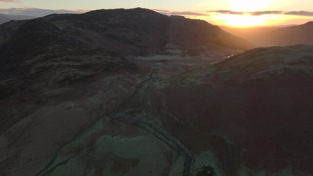 Mountain pass with dawn breaking on the horizon. Blea Tarn Pass, Langdales, English Lake District, Cumbria, UK.