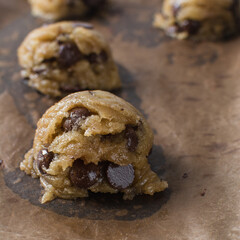 scoops of chocolate chip cookie dough on a baking sheet, homemade chocolate chip cookie dough,...