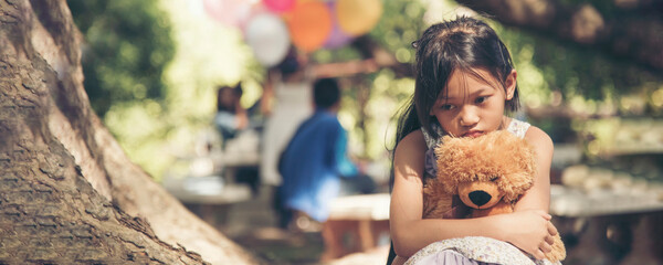 Banner Sad girl hug teddy bear sit sadness alone in green park. Banner Lonely girl feeling sad cry...