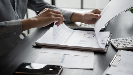 Asian business man holding paper document calculating tax insurance managing budget