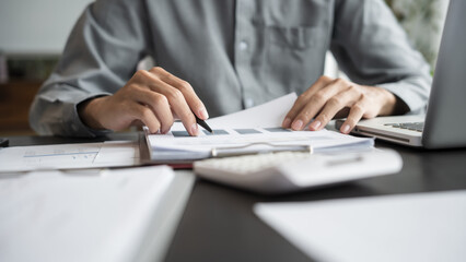 Asian business man holding paper document calculating tax insurance managing budget