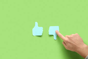 Man pointing at rating thumbs on green background. Survey concept