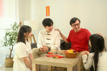 Happy family sharing laughter and stories on the sofa during Chinese New Year celebration