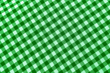 Diagonal green white plaid in the red background. top view of blue checkered tablecloth surface as...