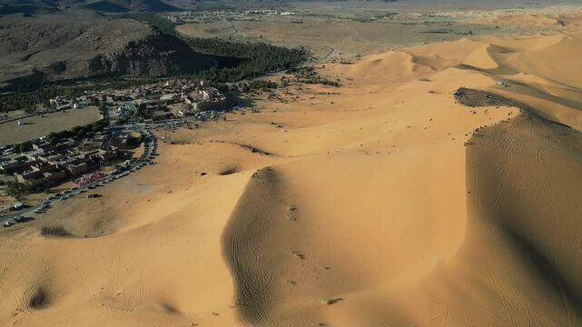 Taghit, a stunning oasis in Algeria's Sahara, blends golden dunes, lush palms, and traditional charm. Aerial views reveal its serene beauty and vibrant desert life.