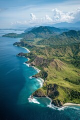 Fototapeta premium Beautiful aerial view of an Indonesian island with green mountains and a blue ocean, featuring white sandy beaches, cliffs, and sea waves.