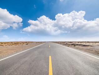 Asphalt highway road and desert natural landscape under the blue sky. Outdoor road background.
