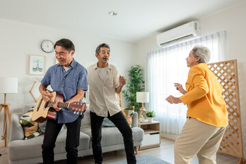 Obraz premium Group of senior friend playing guitar and dancing in living room at home. 