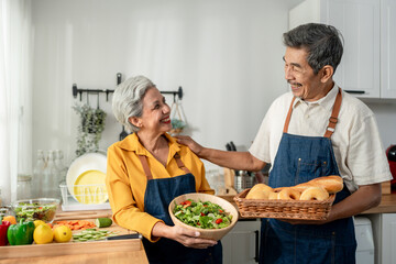 Asian elderly couple preparing food for breakfast in kitchen at home.