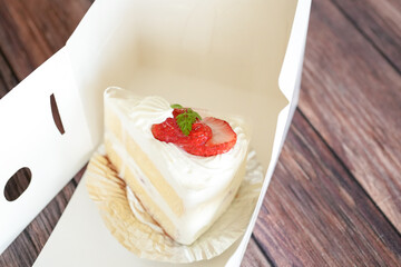 Japanese shortcake with strawberries on top is placed on wooden floor