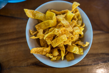 Fried crispy wonton strips in a bowl, free service at noodle restaurants.