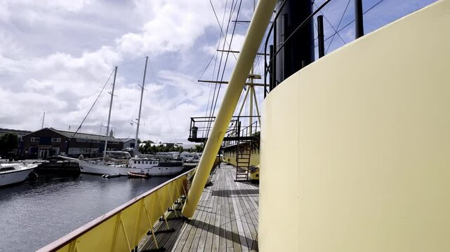 A Walk Through History Exploring the Deck of the HNLMS Schorpioen, a 19th-Century Dutch Warship Docked in Den Helder, on a Partly Cloudy Day