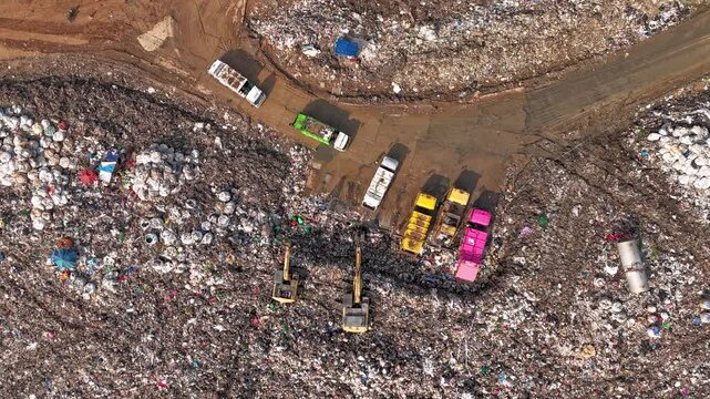 Time-lapse aerial view of large garbage, waste, landfill, workers sorting garbage in a landfill, garbage trucks dumping garbage that causes global warming pollution.