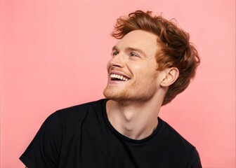 Fototapeta premium Positive Young Redhead Male in Black T-Shirt Smiling and Looking Away – Pink Background