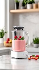 Pink smoothie in a glass blender on a kitchen counter.