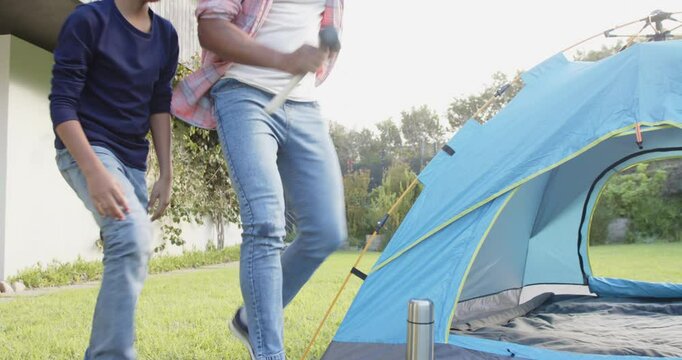 Setting up tent, Indian father and young son bonding outdoors in backyard