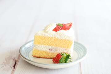 Japanese shortcake with strawberries on top is placed on a white wooden floor
