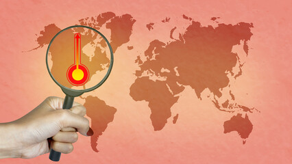 Human hand with magnifying glass looking a thermometer with a high or heat temperature indicator on the earth