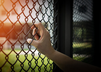 Slavery trade and human trafficking victim concept with woman prisoner slave's hand in jail being...