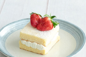 Japanese shortcake with strawberries on top is placed on a white wooden floor