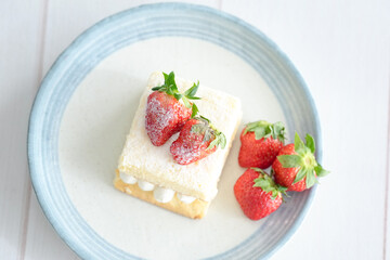 Japanese shortcake with strawberries on top is placed on a white wooden floor