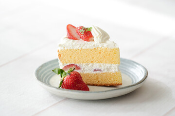 Japanese shortcake with strawberries on top is placed on a white wooden floor