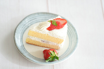 Japanese shortcake with strawberries on top is placed on a white wooden floor