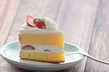 Japanese shortcake with strawberries on top is placed on wooden floor