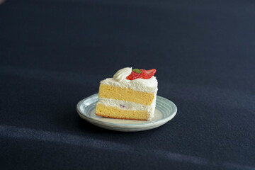 Japanese shortcake with strawberries on top is placed on a black cloth