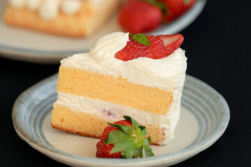 Japanese shortcake with strawberries on top is placed on a black cloth
