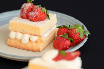 Japanese shortcake with strawberries on top is placed on a black cloth