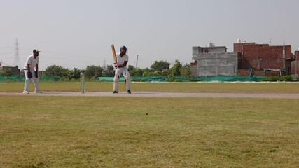 Low view of a batsman hitting a helicopter shot in a cricket match