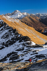 Hiker in the Central Alps with Pizzo Stella, Pizzo Badile and Cengalo on the horizon, Valchiavenna,...