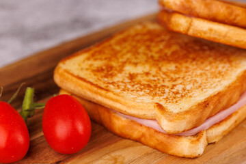 Tasty Cheese and Ham Sandwiches with Juicy Tomatoes on a Dark Concrete Surface