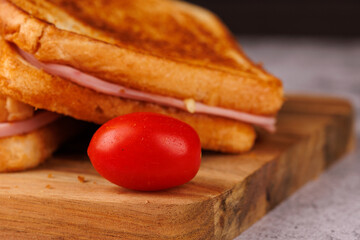 Appetizing Sandwiches and Cherry Tomatoes with a Red Napkin on a Black Background