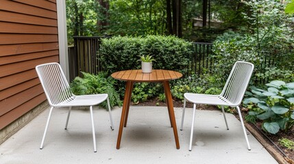Obraz premium Patio furniture seating and minimal, A cozy outdoor seating area featuring a wooden table and two white chairs, surrounded by lush greenery.