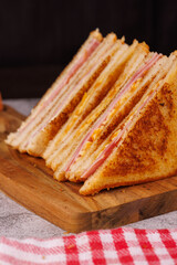 Colorful Ham and Cheese Sandwiches Cut in Half on a Black Table