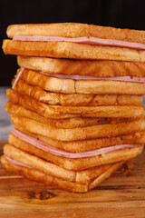 Vertical Stack of Ham and Cheese Sandwiches on a Gray Concrete Table