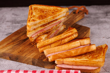 Colorful Ham and Cheese Sandwiches in a Vertical Stack on a Black Table
