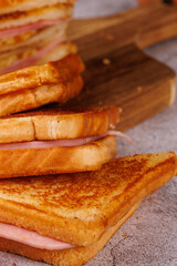 Appetizing Vertical Stack of Ham and Cheese Sandwiches on a Gray Surface