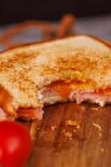 Flavorful Egg, Ham, and Cheese Sandwich with Cherry Tomatoes on a Gray Surface
